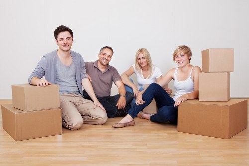 Moving team carrying furniture through a Northkensington property
